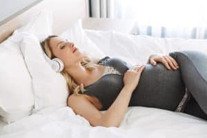 Pregnant woman sleeping with headphones